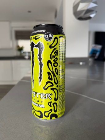 Phone photo of a yellow energy drink can standing on a grey kitchen worktop